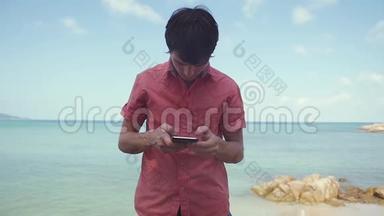 商人使用智能手机站在热带海滩附近。 慢动作。 1920x1080
